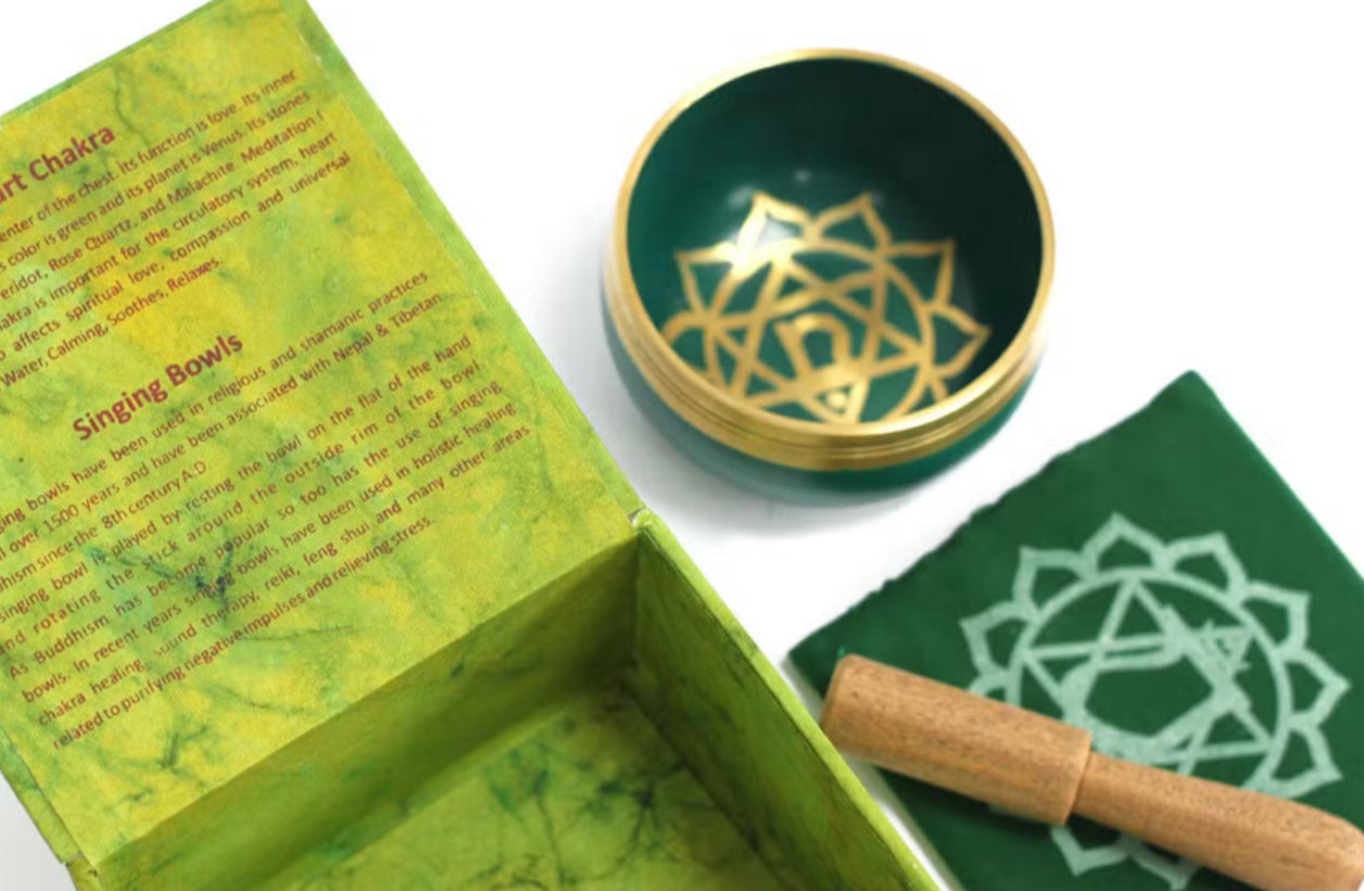 Singing bowl with gold design on a green box and mat