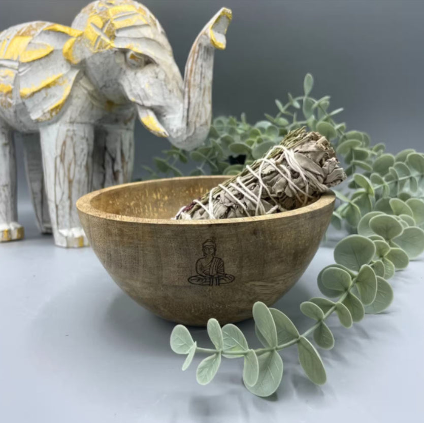 Wooden bowl with sage and elephant figurine on a gray background