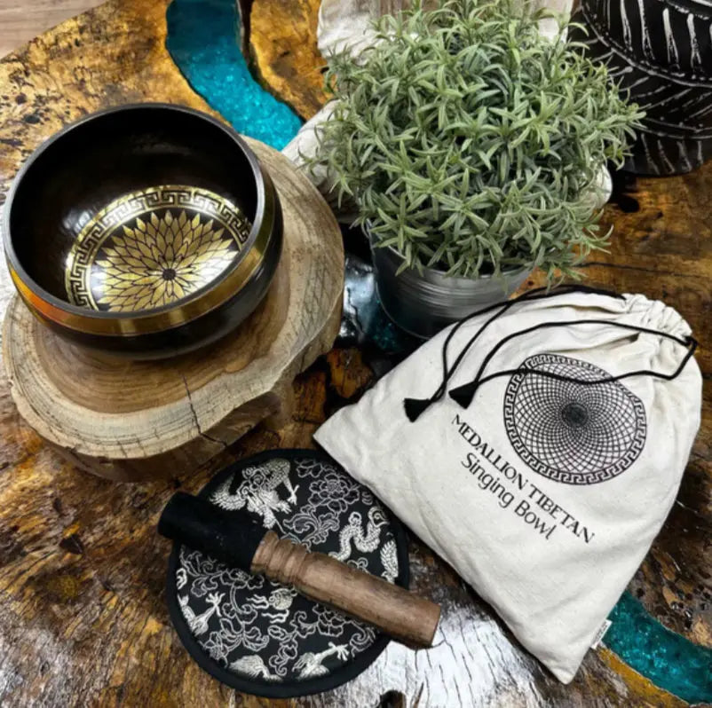 Tibetan singing bowl set with accessories on a wooden surface
