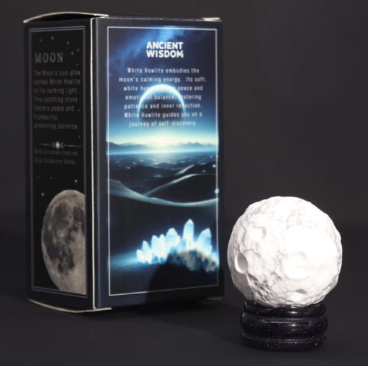 Decorative white Howlite gemstone moon planet resting on a glittering Sola Goldstone stand