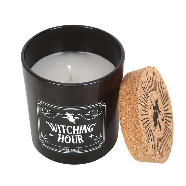 Candle in a black container with 'Witching Hour' label and cork lid on a white background